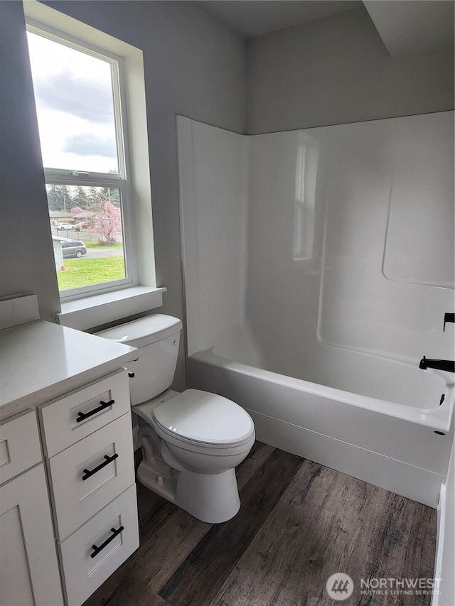 full bathroom featuring toilet, vanity, shower / tub combination, and wood finished floors