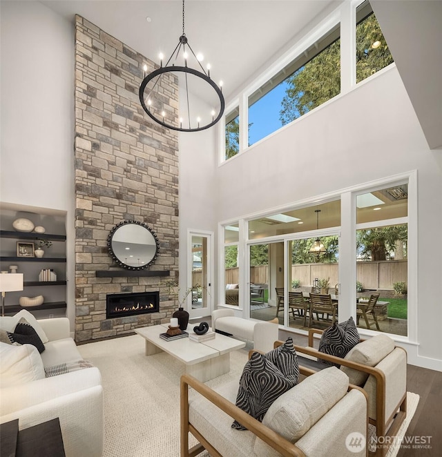living area with a fireplace, wood finished floors, and an inviting chandelier