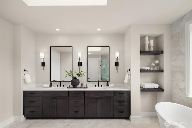 bathroom featuring a freestanding tub, double vanity, built in features, and a sink