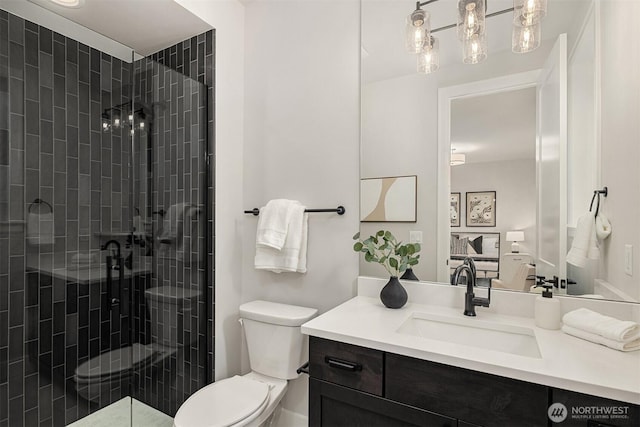 bathroom with toilet, a stall shower, and vanity