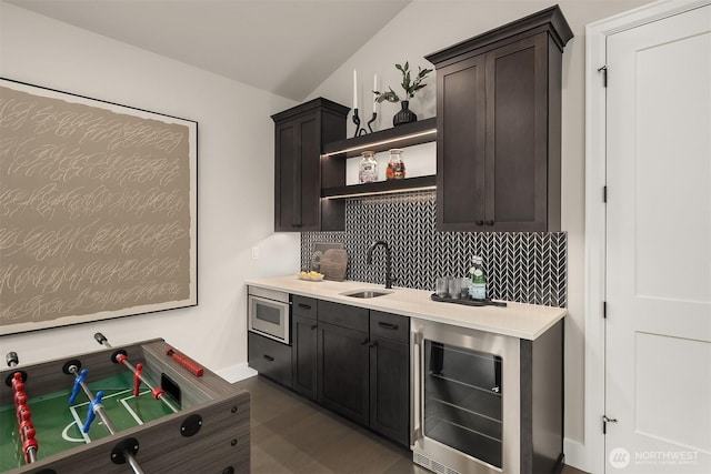 kitchen with stainless steel microwave, wine cooler, tasteful backsplash, a sink, and open shelves