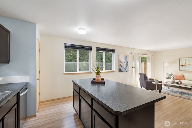 kitchen with dark countertops, light wood-type flooring, healthy amount of natural light, and dishwasher