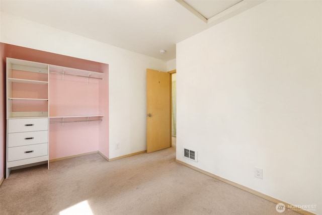 unfurnished bedroom featuring light colored carpet, a closet, and baseboards