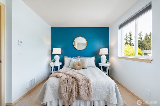 bedroom featuring baseboards, carpet, and an accent wall