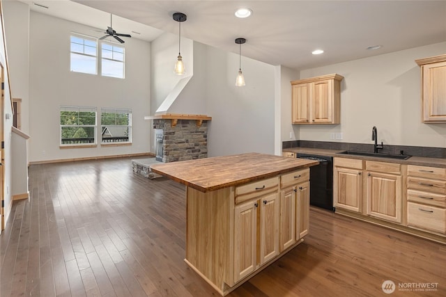 kitchen featuring a sink, open floor plan, dishwasher, and light brown cabinets