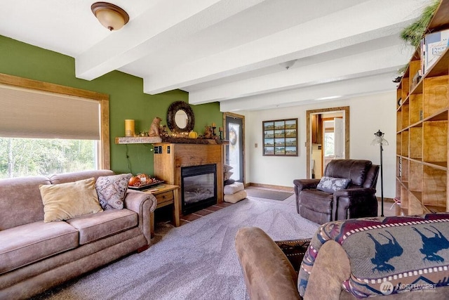 living area with a fireplace with flush hearth, baseboards, beamed ceiling, and carpet flooring