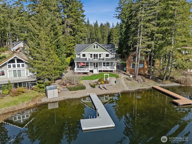 back of property featuring an outbuilding and a deck with water view
