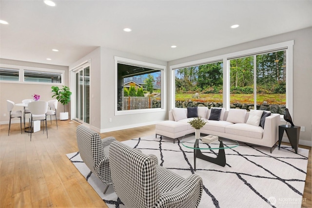 living room featuring baseboards, recessed lighting, and light wood-style flooring