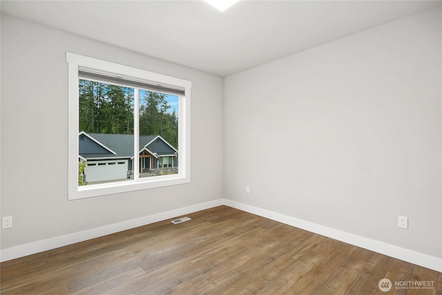 unfurnished room with baseboards and wood finished floors