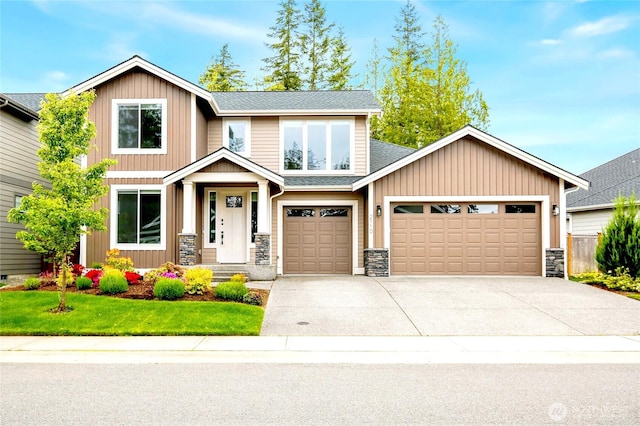 craftsman-style home featuring driveway, stone siding, a shingled roof, an attached garage, and a front yard