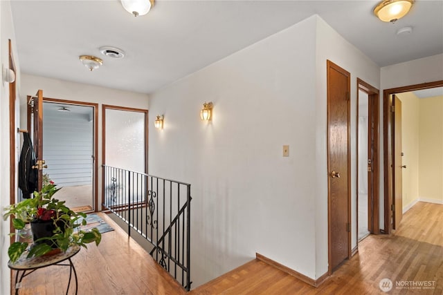 312 N Perry Ave, East Wenatchee, WA 98802 - hall with light wood-style flooring, baseboards, visible vents, and an upstairs landing