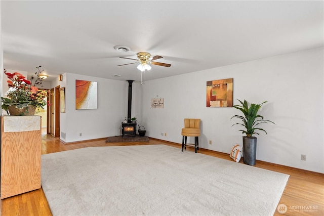 312 N Perry Ave, East Wenatchee, WA 98802 - unfurnished room with visible vents, light wood-style flooring, a wood stove, and a ceiling fan