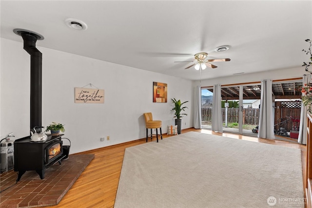 312 N Perry Ave, East Wenatchee, WA 98802 - sitting room featuring a wood stove, baseboards, light wood-style floors, visible vents, and a ceiling fan