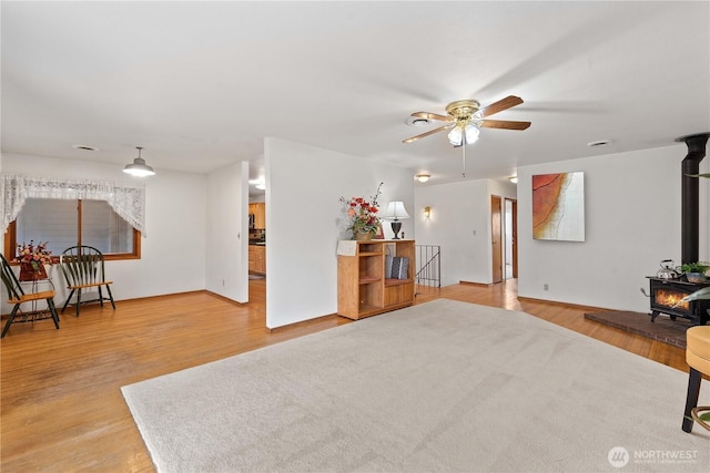 312 N Perry Ave, East Wenatchee, WA 98802 - sitting room featuring light wood-style floors, ceiling fan, and a wood stove