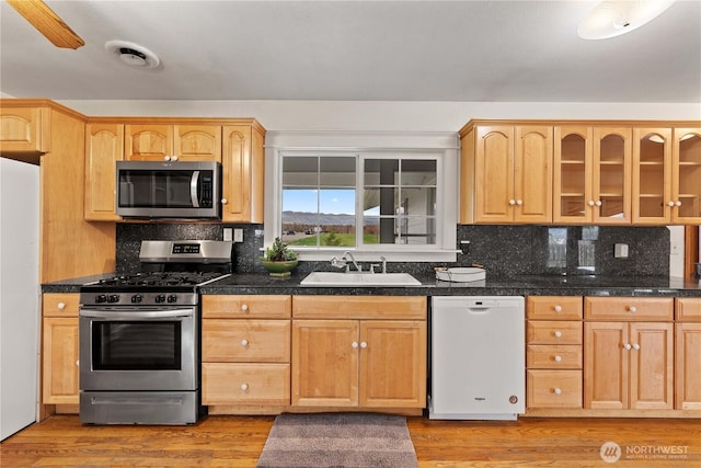312 N Perry Ave, East Wenatchee, WA 98802 - kitchen with visible vents, a sink, backsplash, and appliances with stainless steel finishes