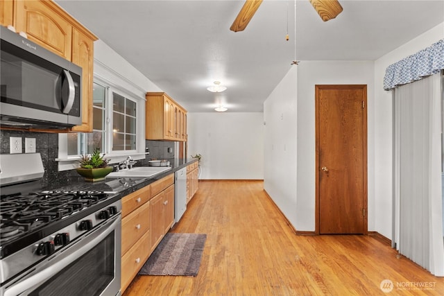312 N Perry Ave, East Wenatchee, WA 98802 - kitchen with dark countertops, tasteful backsplash, appliances with stainless steel finishes, a sink, and light wood-type flooring