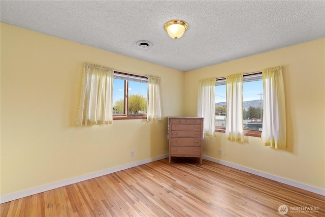 312 N Perry Ave, East Wenatchee, WA 98802 - unfurnished room with a wealth of natural light, visible vents, wood finished floors, and baseboards