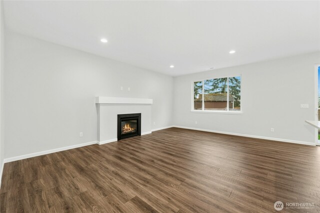 27113 30th Pl S Unit 23, Kent, WA 98032 - unfurnished living room with dark wood-type flooring, a glass covered fireplace, recessed lighting, and baseboards