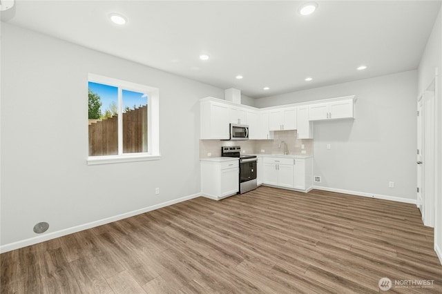 27113 30th Pl S Unit 23, Kent, WA 98032 - kitchen with appliances with stainless steel finishes, baseboards, light wood-type flooring, a sink, and recessed lighting