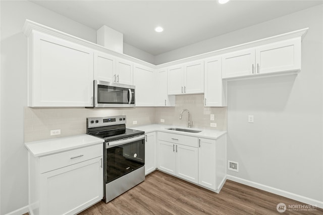 27113 30th Pl S Unit 23, Kent, WA 98032 - kitchen featuring stainless steel appliances, a sink, white cabinetry, wood finished floors, and recessed lighting