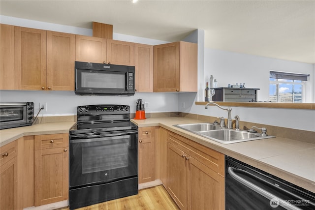 500 Elliott Ave W Unit 309, Seattle, WA 98119 - kitchen featuring black appliances, a sink, light countertops, and light wood finished floors