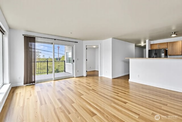 500 Elliott Ave W Unit 309, Seattle, WA 98119 - unfurnished living room featuring light wood-style flooring and baseboards
