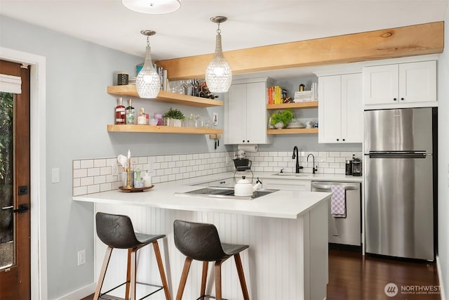 756 N 72nd St Unit 101, Seattle, WA 98103 - kitchen featuring a sink, a kitchen bar, open shelves, decorative backsplash, and appliances with stainless steel finishes