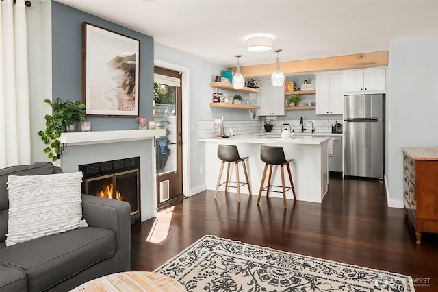 756 N 72nd St Unit 101, Seattle, WA 98103 - interior space with a peninsula, a breakfast bar area, freestanding refrigerator, open shelves, and light countertops