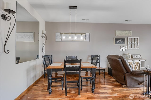 dining room with visible vents, baseboards, and wood finished floors