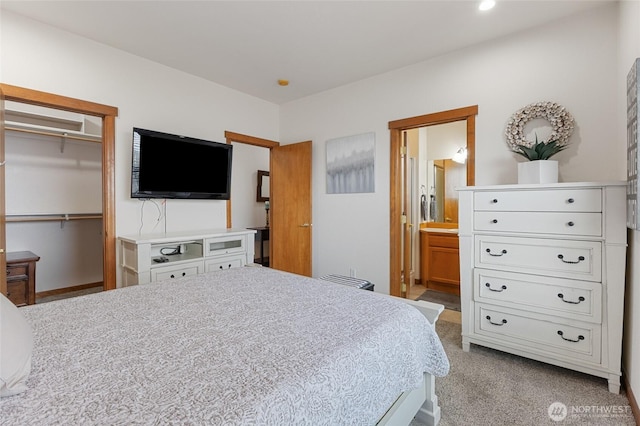 bedroom with carpet flooring, ensuite bath, a spacious closet, and a closet