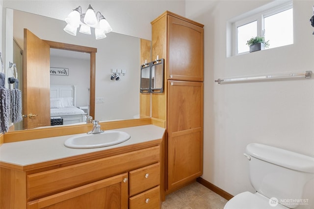 bathroom with tile patterned flooring, vanity, toilet, ensuite bathroom, and a notable chandelier
