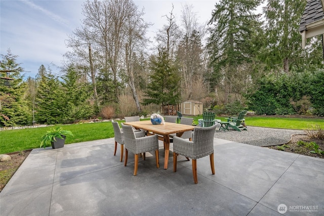 view of patio featuring outdoor dining area, a storage shed, and an outbuilding