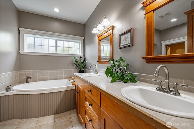 bathroom with tile patterned flooring, a bath, visible vents, and a sink