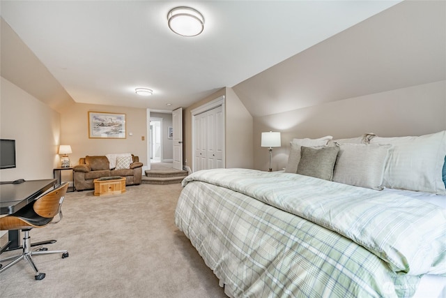 bedroom featuring light carpet, a closet, and lofted ceiling