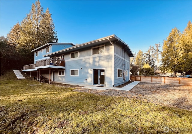 back of house with a wooden deck, a fenced backyard, french doors, and a yard