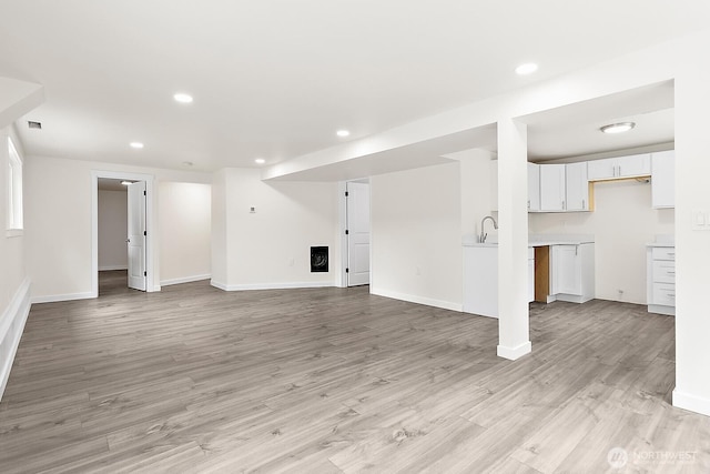 unfurnished living room featuring baseboards, light wood-style flooring, and recessed lighting