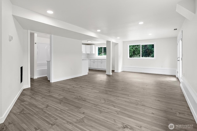 unfurnished living room featuring baseboards, wood finished floors, and recessed lighting