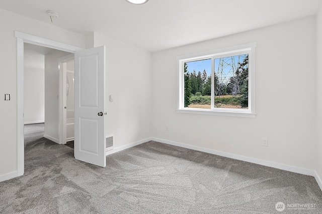 carpeted empty room featuring baseboards and visible vents