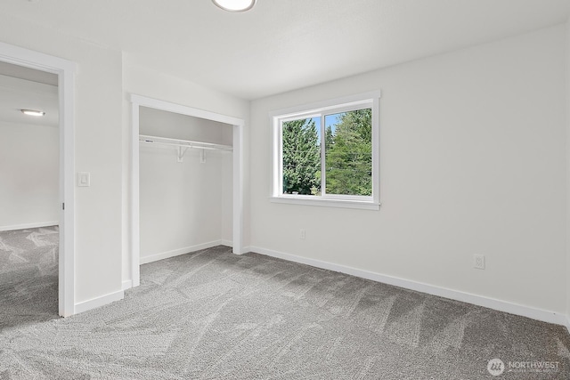 unfurnished bedroom with baseboards, carpet flooring, and a closet