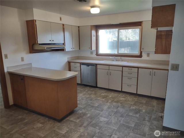 312 SE 9th St, College Place, WA 99324 - kitchen featuring light countertops, stone finish flooring, a sink, a peninsula, and stainless steel dishwasher