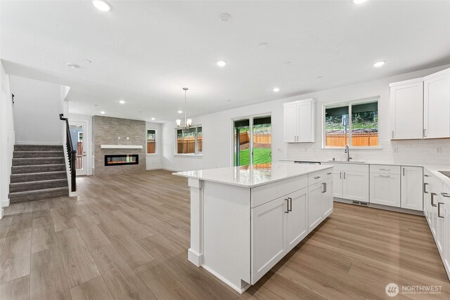 15710 210th Ave E Unit 311, Bonney Lake, WA 98391 - kitchen with a sink, light wood-style floors, backsplash, a kitchen island, and recessed lighting