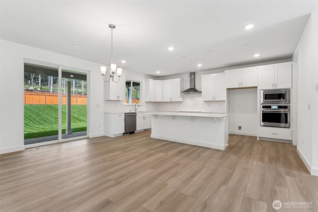 15710 210th Ave E Unit 311, Bonney Lake, WA 98391 - kitchen featuring appliances with stainless steel finishes, wall chimney exhaust hood, white cabinetry, a chandelier, and light countertops