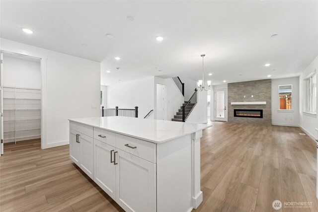 15710 210th Ave E Unit 311, Bonney Lake, WA 98391 - kitchen featuring light wood finished floors, a center island, white cabinets, recessed lighting, and open floor plan