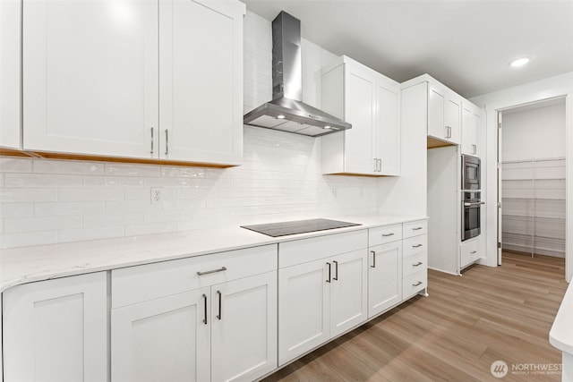 15710 210th Ave E Unit 311, Bonney Lake, WA 98391 - kitchen featuring wall chimney exhaust hood, stainless steel appliances, white cabinetry, light wood-style flooring, and recessed lighting