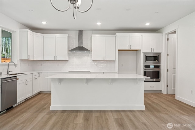 15710 210th Ave E Unit 311, Bonney Lake, WA 98391 - kitchen featuring appliances with stainless steel finishes, wall chimney range hood, a sink, backsplash, and recessed lighting