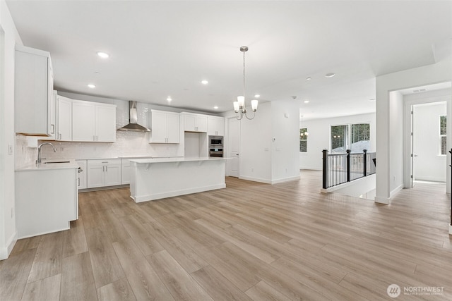 15710 210th Ave E Unit 311, Bonney Lake, WA 98391 - kitchen with wall chimney exhaust hood, a sink, appliances with stainless steel finishes, recessed lighting, and a chandelier