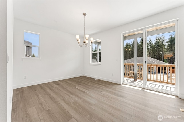 15710 210th Ave E Unit 311, Bonney Lake, WA 98391 - unfurnished dining area with a chandelier, light wood-style flooring, and baseboards