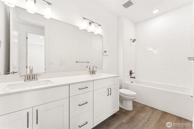 15710 210th Ave E Unit 311, Bonney Lake, WA 98391 - bathroom featuring wood finished floors, toilet, double vanity,  shower combination, and recessed lighting
