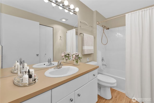 full bath featuring vanity, wood finished floors, shower / bath combo, and toilet