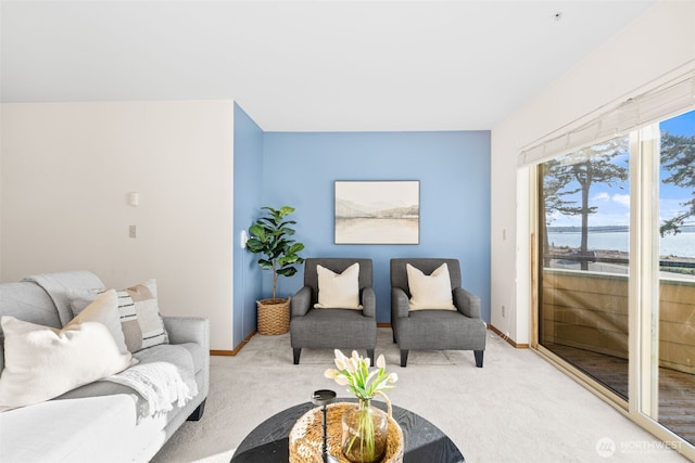 living area featuring baseboards and light colored carpet